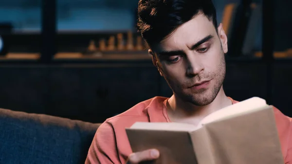 Homme concentré lecture livre à la maison — Photo de stock