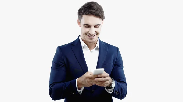 Hombre de negocios sonriente en traje usando teléfono inteligente aislado en blanco - foto de stock