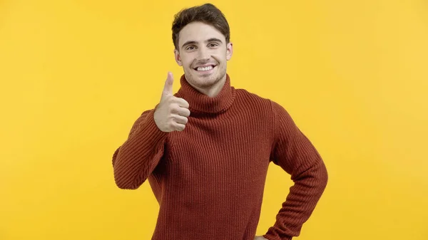 Uomo positivo in maglione che mostra come isolato sul giallo — Foto stock