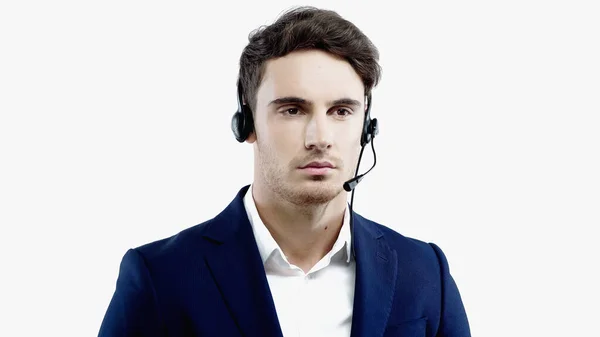 Joven hombre de negocios con traje y auriculares de pie aislado en blanco - foto de stock