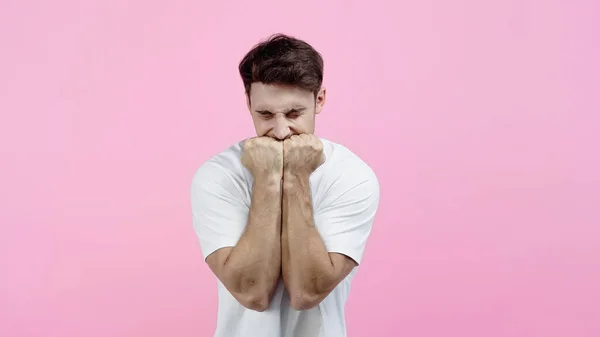 Hombre deprimido cogido de la mano en puños aislados en rosa - foto de stock