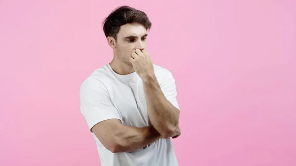 Pensive and worried man with hand near mouth looking away isolated on pink — Stock Photo