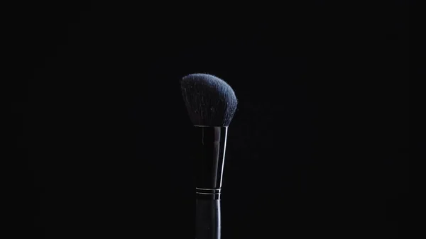 Soft cosmetic brush with blue powder isolated on black — Stock Photo