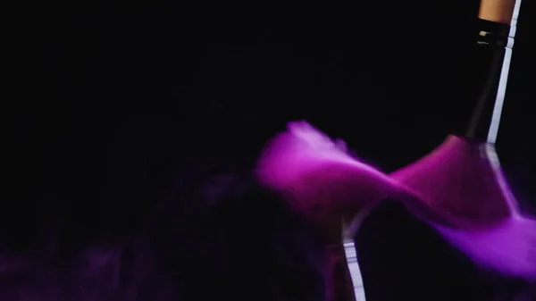 Verschwommene Kosmetikpinsel mit violettem Puder, das auf schwarzem Hintergrund spritzt — Stockfoto