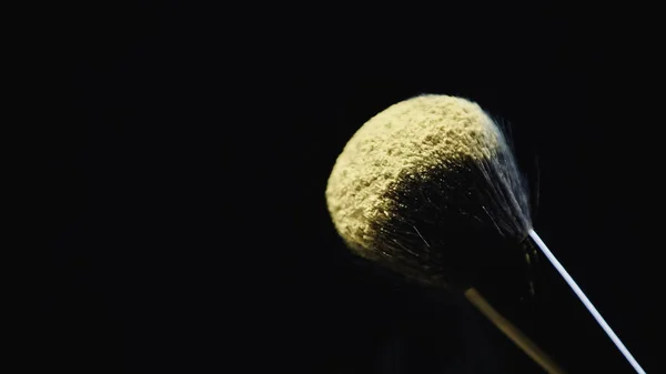 Peinture holi jaune sur pinceau cosmétique doux isolé sur noir — Photo de stock