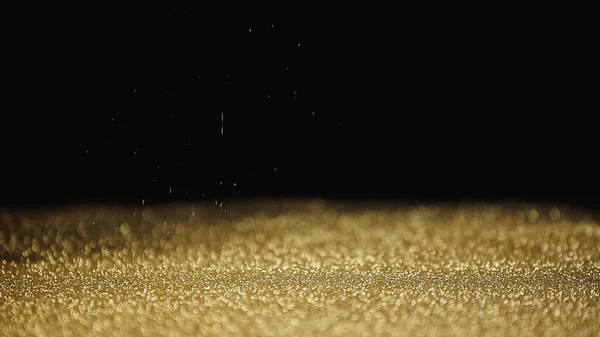 Blurred and sparkling golden dust on black background — Stock Photo