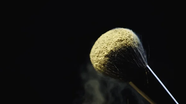 Poudre holi jaune sur pinceau cosmétique doux isolé sur noir — Photo de stock
