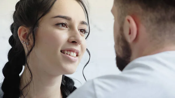 Sonriente mujer mirando borrosa hombre aislado en blanco - foto de stock