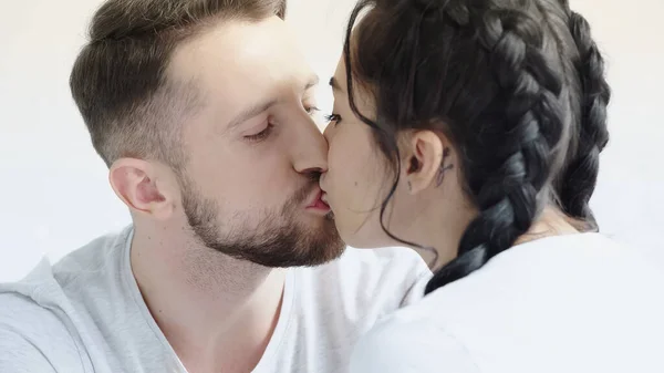 Mujer joven con trenzas y hombre besándose en casa - foto de stock