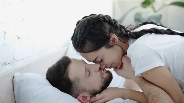 Bearded man kissing young brunette girlfriend — Photo de stock