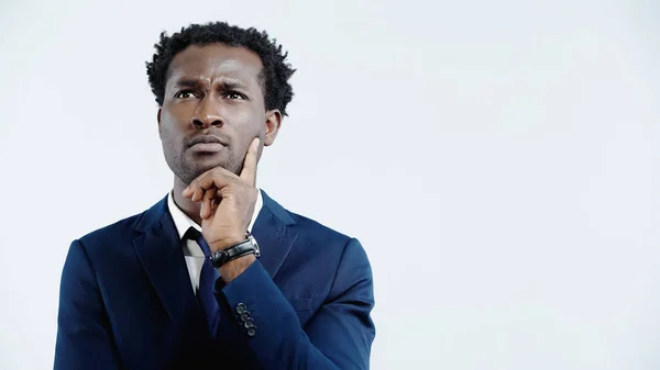 Nachdenklicher afrikanisch-amerikanischer Geschäftsmann im Anzug schaut weg, während er isoliert auf blauem Grund denkt — Stockfoto