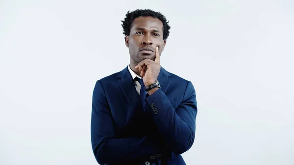 Pensive african american businessman in formal wear thinking isolated on blue — Stock Photo