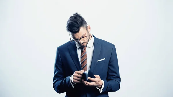 Young businessman looking into wallet isolated on white — Stock Photo