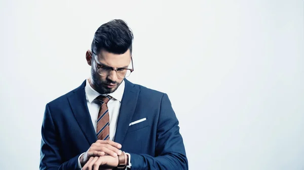 Joven hombre de negocios comprobar el tiempo en reloj de pulsera aislado en blanco - foto de stock