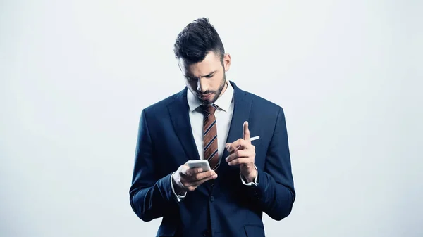 Thoughtful businessman showing attention gesture while using cellphone isolated on white — Stock Photo