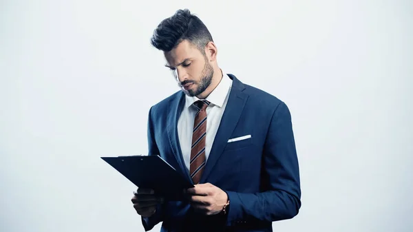 Young pensive businessman looking at clipboard isolated on white — Stock Photo