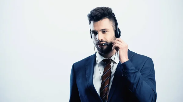 Sonriente operador del centro de llamadas ajustando auriculares aislados en blanco - foto de stock