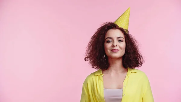 Pleased young woman in party cap isolated on pink — Stock Photo