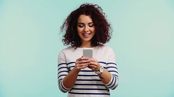 Молодая счастливая женщина в чате по мобильному телефону изолированы на синий — стоковое фото