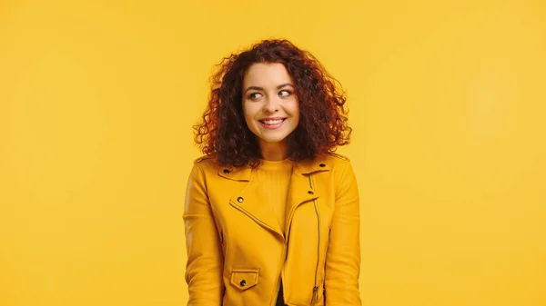 Heureux jeune et bouclée femme regardant loin isolé sur jaune — Photo de stock