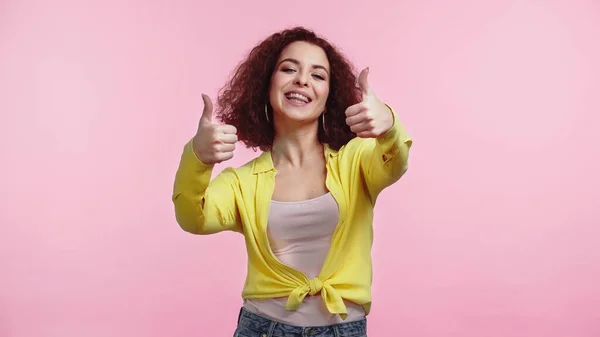 Junge glückliche Frau zeigt vereinzelt Daumen nach oben auf rosa — Stockfoto