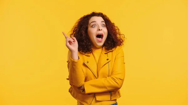 Amazed young woman having idea isolated on yellow — Stock Photo