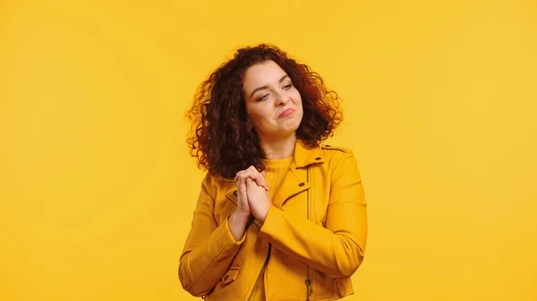 Proud young woman with clenched hands looking away isolated on yellow — Stock Photo