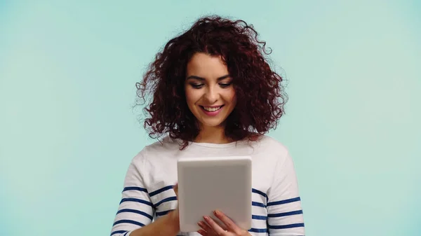 Heureuse jeune femme en utilisant tablette numérique isolé sur bleu — Photo de stock