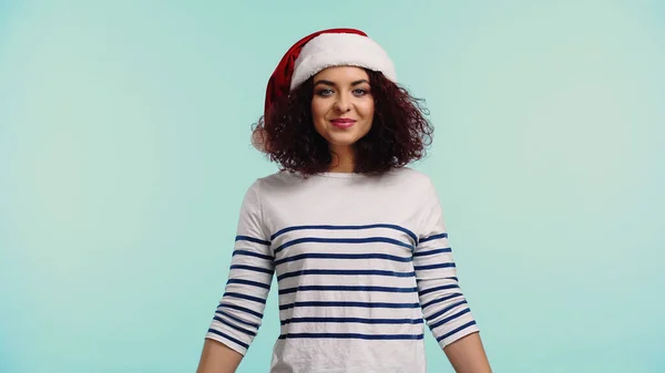 Happy young woman in santa hat isolated on blue — Stock Photo