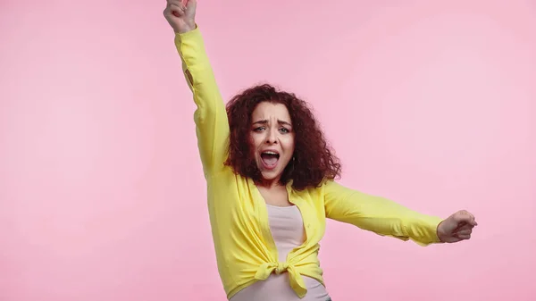 Aufgeregte junge Frau mit erhobener Hand jubelt vereinzelt auf rosa — Stockfoto