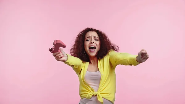 QUIIV, UCRÂNIA - JUNHO 30, 2021: jovem excitada segurando joystick e se alegrando isolada em rosa — Fotografia de Stock