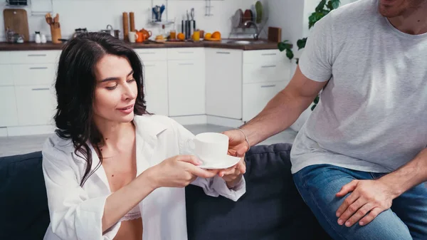 Jovem dando xícara de café para mulher em camisa desabotoada — Fotografia de Stock