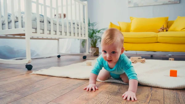 Säugling krabbelt im Wohnzimmer auf dem Boden — Stockfoto