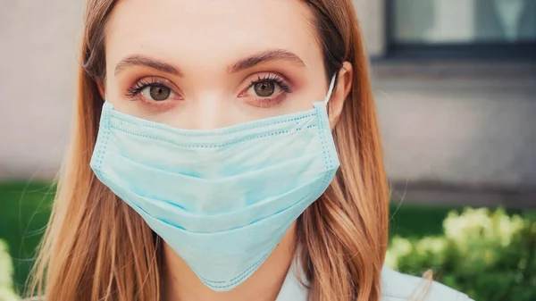 Nahaufnahme einer jungen Studentin in medizinischer Maske, die in die Kamera blickt — Stockfoto