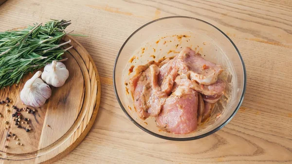 Top view of marinated sliced chicken with rosemary in bowl — Stock Photo