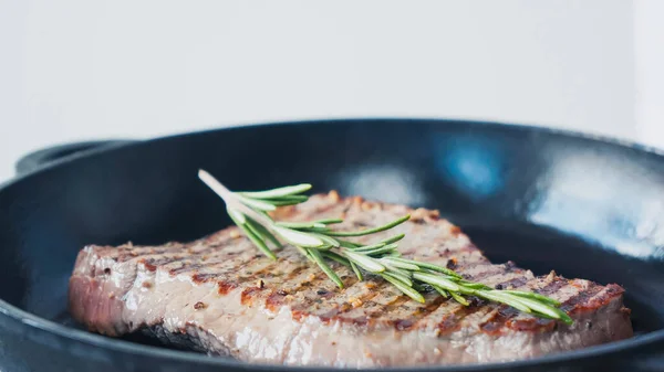 Primo piano di ramo di rosmarino verde su bistecca di manzo fritta — Foto stock