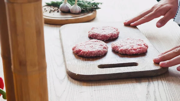 Abgeschnittene Ansicht des Chefs in der Nähe geformte Hackfleischpastete auf Schneidebrett — Stockfoto