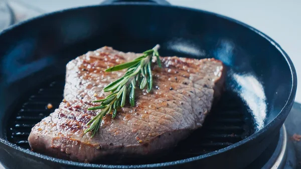 Close up of fresh rosemary branch on beef steak — Stock Photo