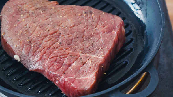Close-up de bife de carne crua na panela grelha — Fotografia de Stock