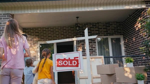 Vue arrière de la famille déménageant dans une nouvelle maison — Photo de stock