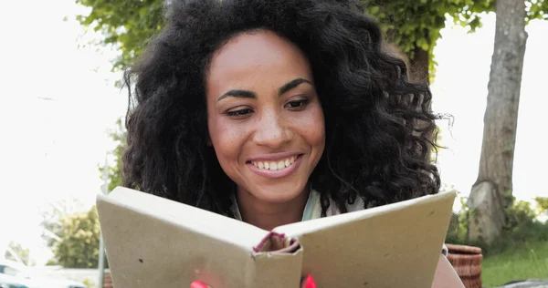 Sorrindo afro-americana leitura livro em capa dura — Fotografia de Stock