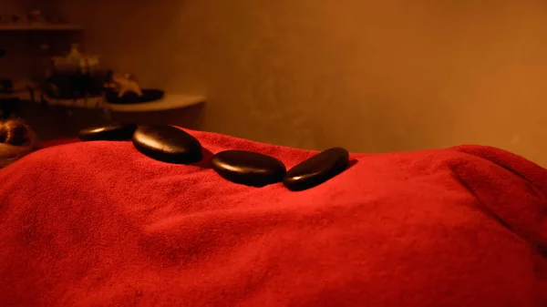 Pierres chaudes sur le dos du client couché sur la table de massage — Photo de stock