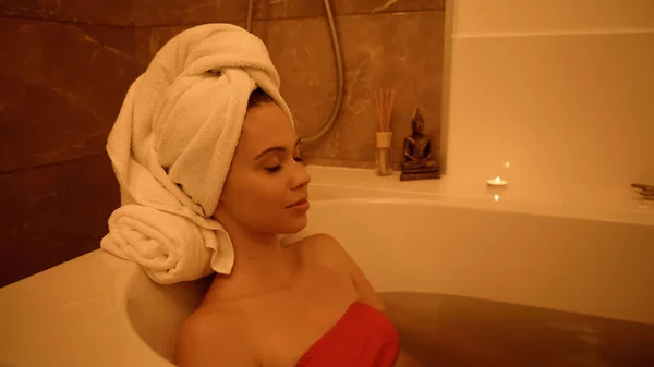 Jeune femme dans la baignoire avec de l'eau dans le centre de bien-être — Photo de stock