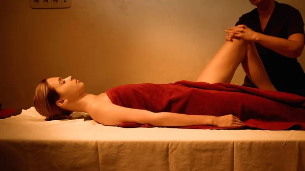 Visão lateral da jovem mulher recebendo massagem nas pernas de massagista profissional — Fotografia de Stock