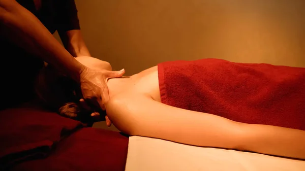 Mujer joven recibiendo masaje en el cuello de masajista profesional en el salón de spa - foto de stock