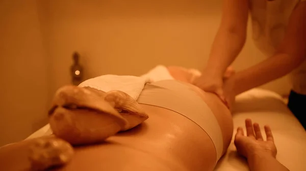 Cropped view of woman receiving massage with sea shells — Stock Photo