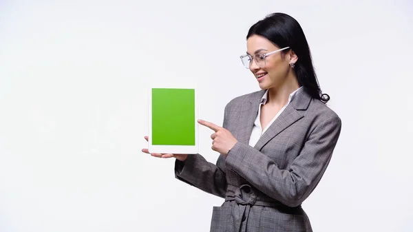 Mujer de negocios sonriente apuntando a la tableta digital con croma clave aislada en blanco - foto de stock