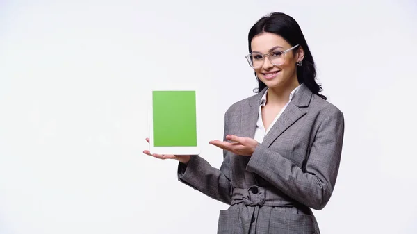 Empresária sorrindo ao apontar para tablet digital com tela verde isolada em branco — Fotografia de Stock