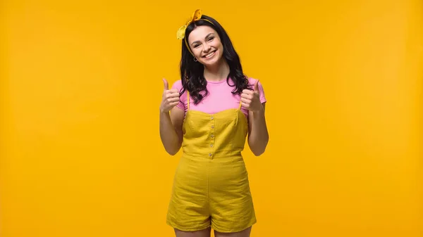 Mulher alegre mostrando polegares isolados no amarelo — Fotografia de Stock