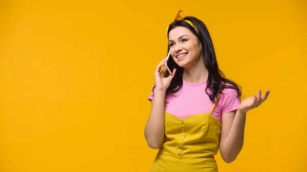 Femme souriante parlant sur téléphone portable isolé sur jaune — Photo de stock